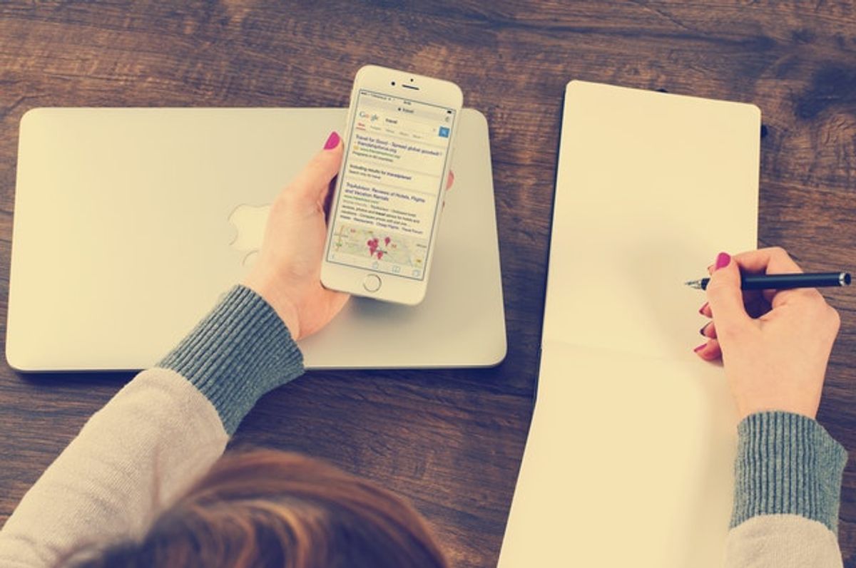 Ein User benutzt sein Smartphone anstatt des Laptops