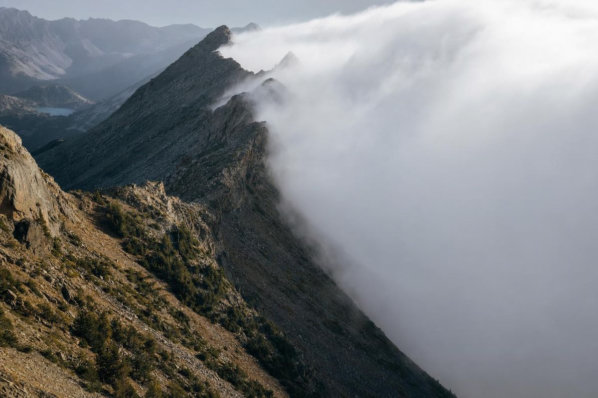 Wetterumschwung über einem Bergkamm: eine Seite sonnig, über der anderen türmen sich Wolken